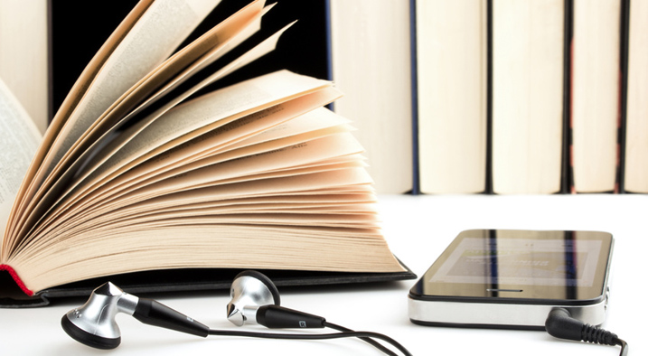 Hörpspiel 05 717x394px Ein aufgeblättertes Buch und ein Smartphone mit Kopfhörern