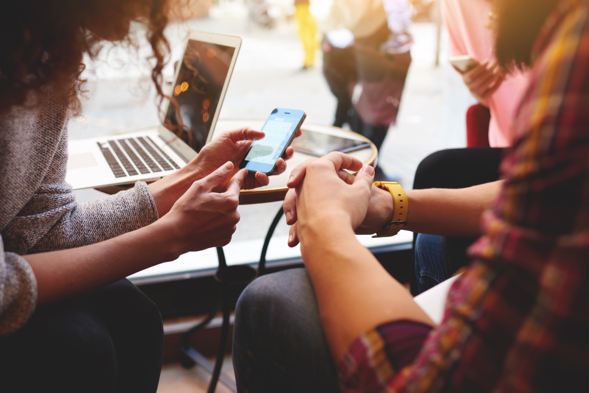 Nahaufnahme von Händen, Smartphones und Laptops