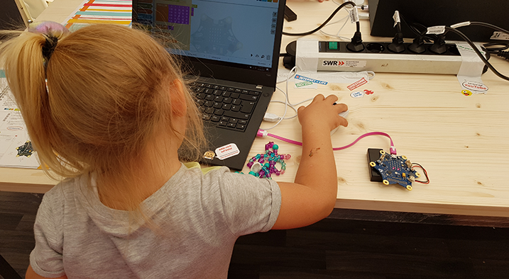 Kleines Mädchen vor einem Laptop mit Mikrocontroller