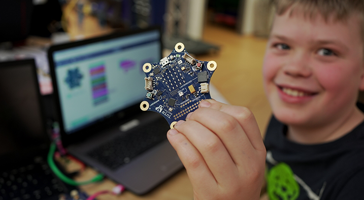 Junge vor PC zeigt Mikrocontroller