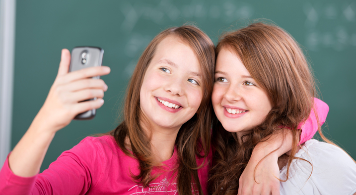 Zwei junge Mädchen machen ein Selfie von sich.