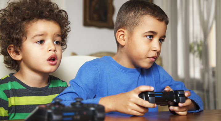 Zwei Jungen mit Controllern spielen Computer.